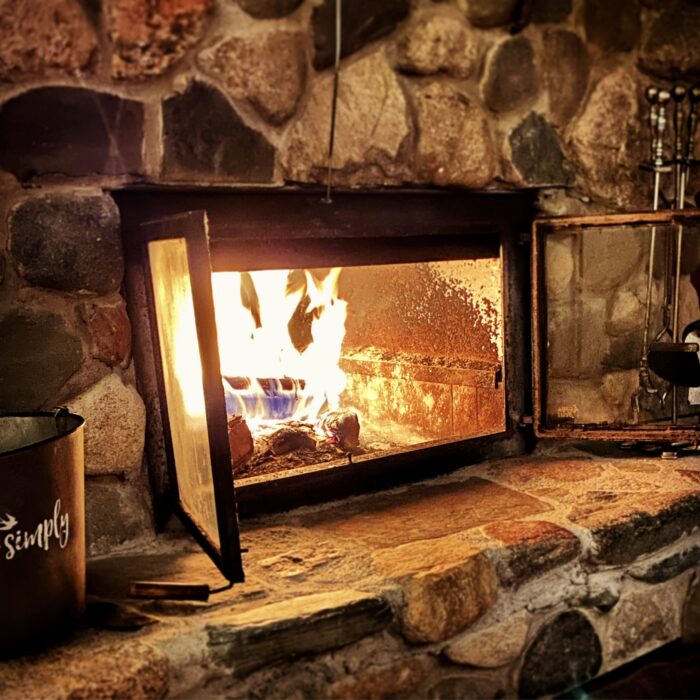 A blazing fire in the beautiful river-rock fireplace at Sugar Maple at Hansen Lake.